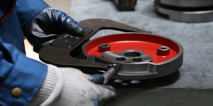 A quality inspector is checking the dimensions of the casting part.